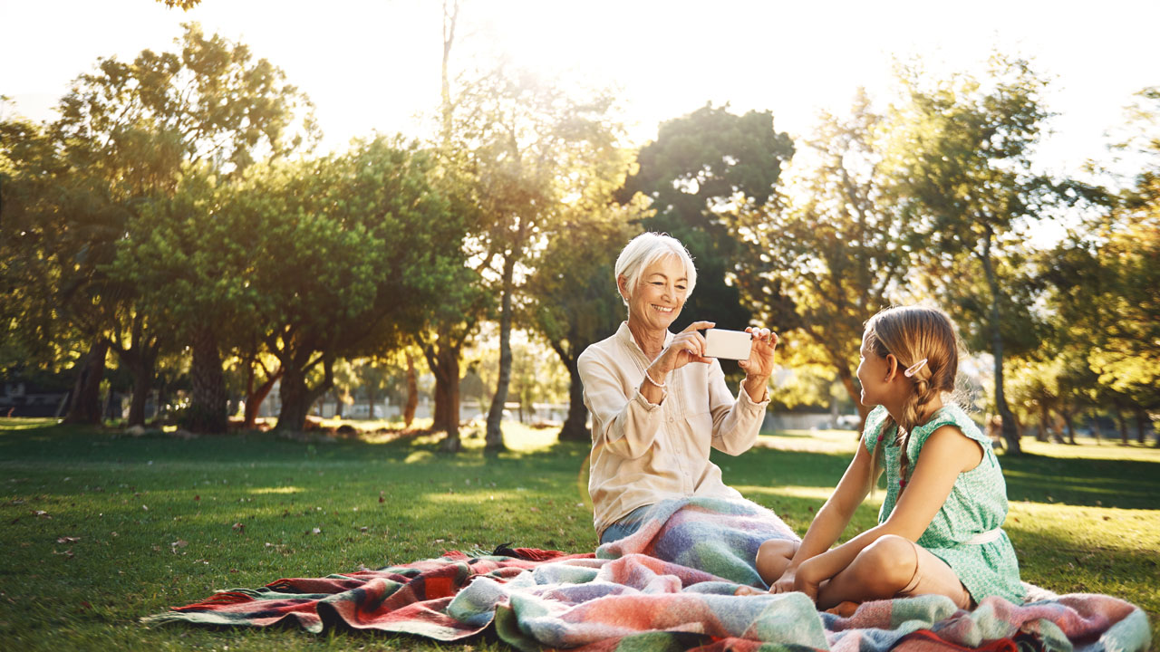 Older woman taking picture of her grandaughter